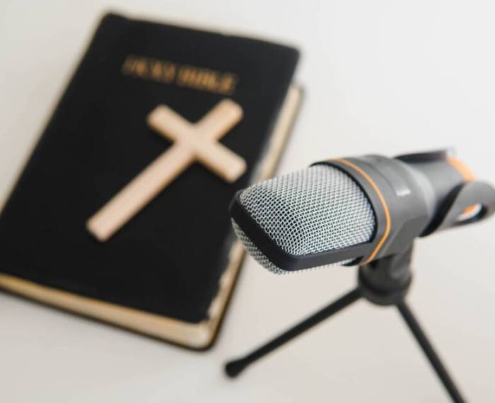 Bible book with microphone on table. Christian radio broadcast. Man records a online podcast.